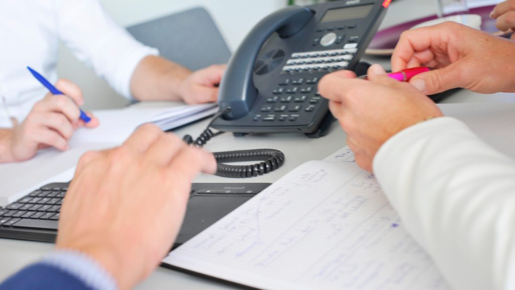 DWS-Versicherungen-Hintergrundbild Hände auf Tisch mit Telefon