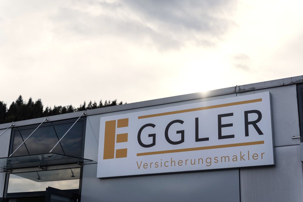Ansicht Gebäude mit Sonnenstrahlen im Hintergrund und Aufschrift "Eggler" der Firma Eggler Bruck/Mur - Partner von DWS